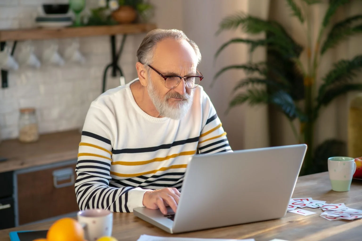 Grey-haired bearded senior man eyeglasses looking concentrated